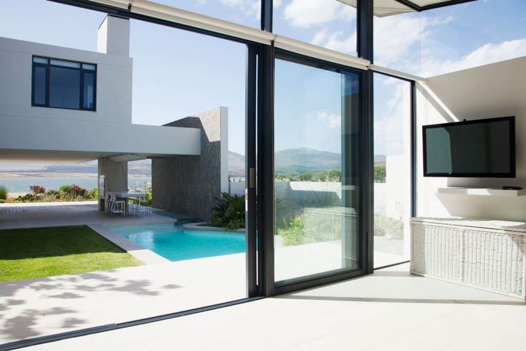 View of patio and swimming pool through sliding doors of modern house, Can A Glass Door Break from Heat?