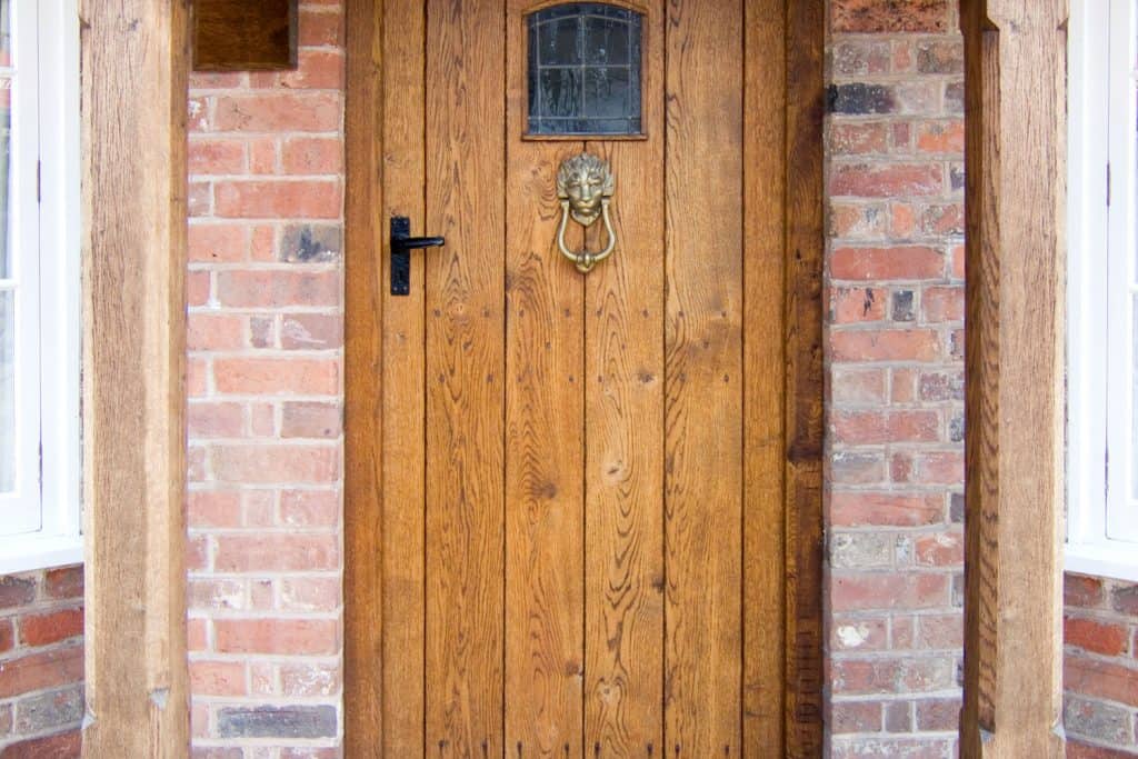 Old Oak Door with Welcome Mat, Do Oak Doors Warp? [And Tips On How To Prevent Warping]
