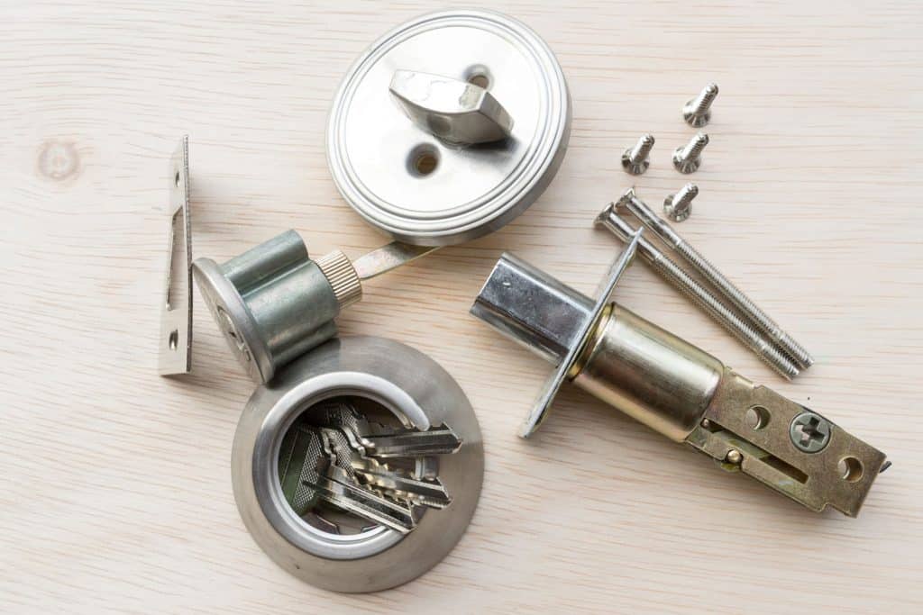 A deadbolt lock along with other screws and mechanism on the table