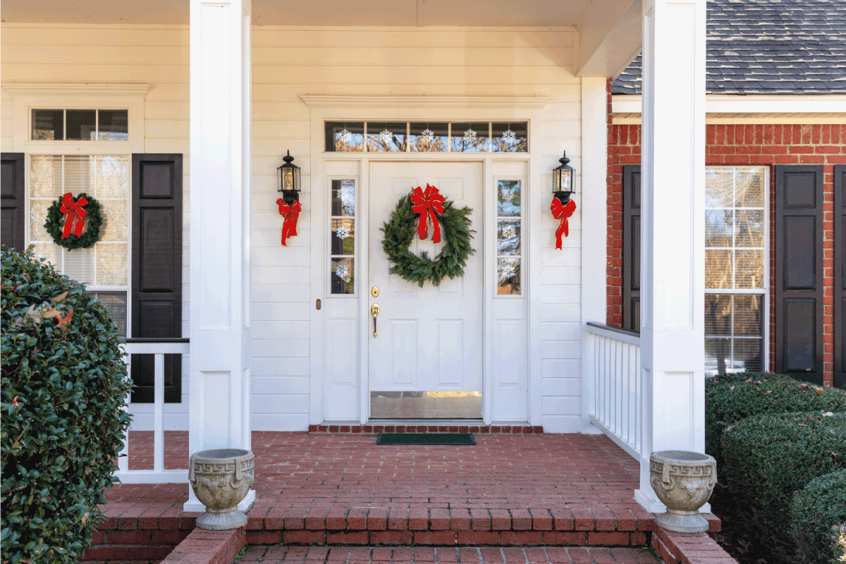 Front Porch and door decorated for the Christmas holiday season. wreath hung on a storm door