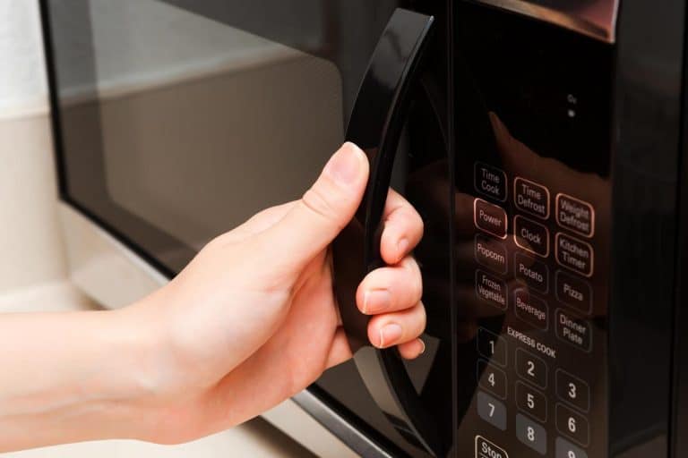 Hand holding microwave door, How To Replace A GE Microwave Door Handle In 5 Easy Steps