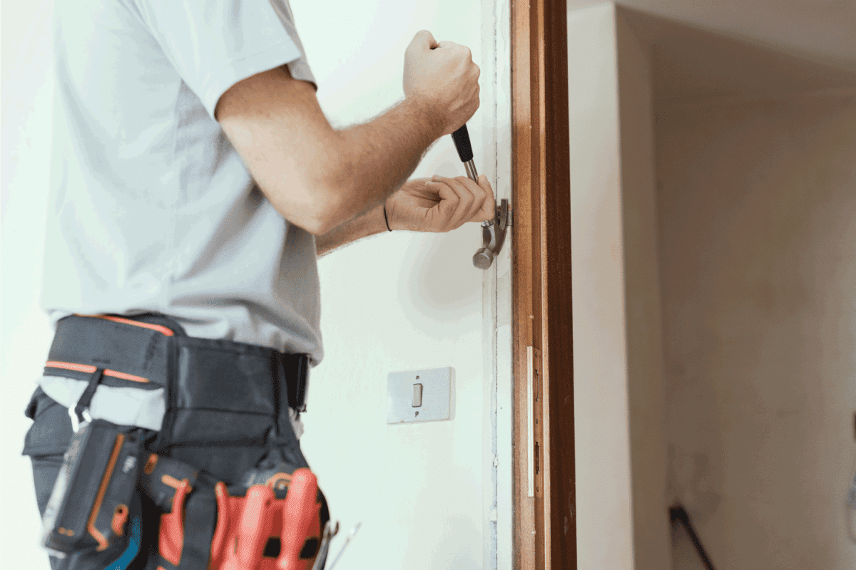 Professional carpenter removing an old door at home