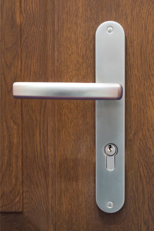 brown wood door with wood stain and stainless steel door handle