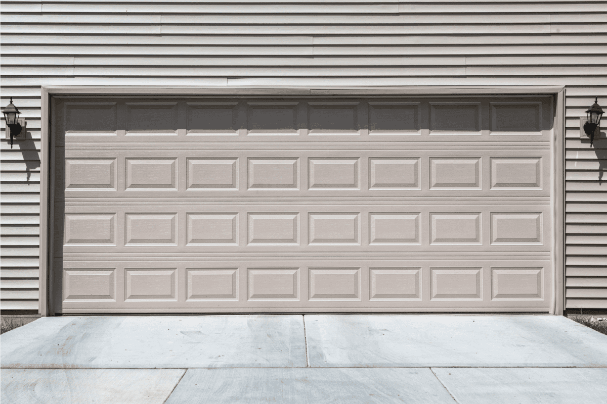 two door car garage of a suburban home with paved driveway