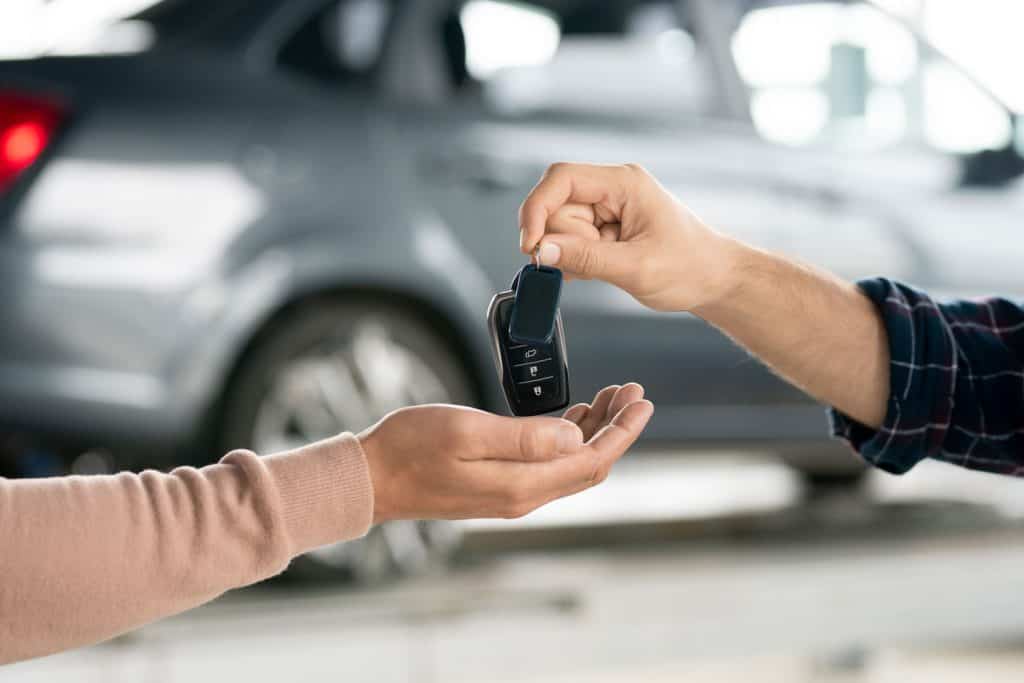 A man giving his keys to the car owner, How Close Does A Transponder Key Have To Be To Work