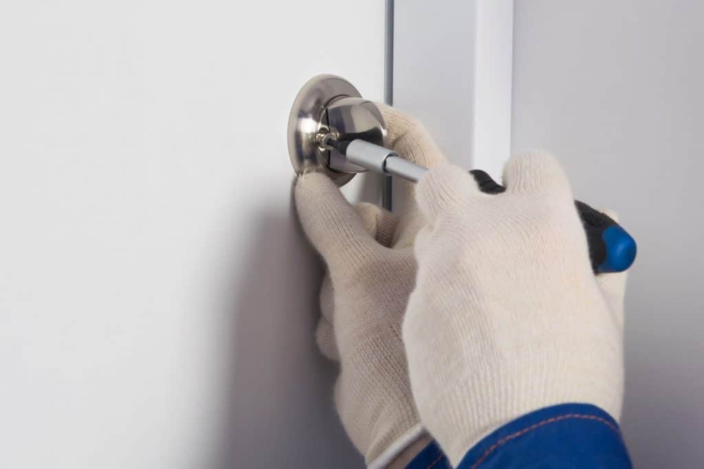 A man installing a deadbolt lock on the front door