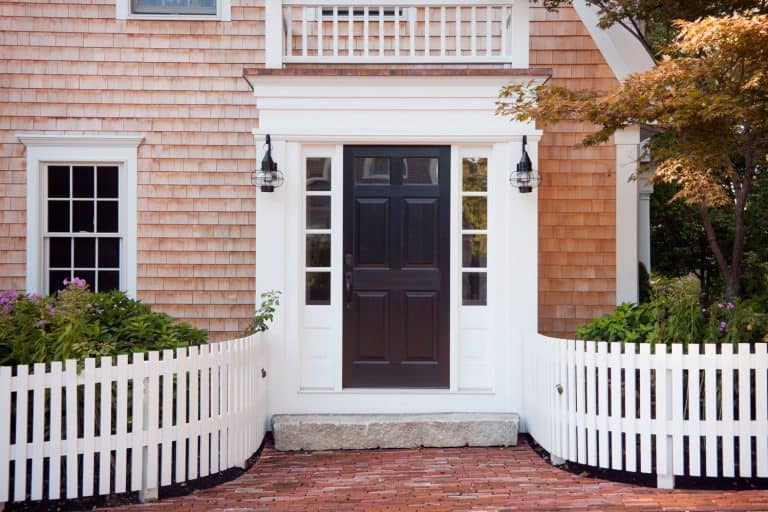 A white framed front door with glass panels on the sides and gorgeous white fences for the garden, How To Lubricate A Storm Door Closer