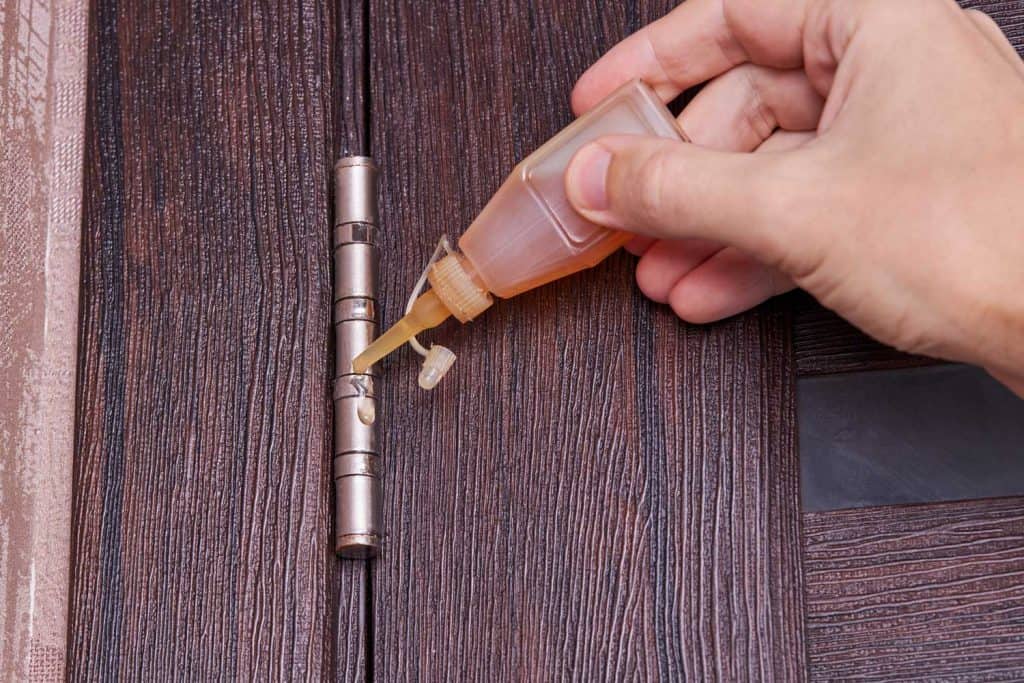 Adjusting door hinge using lubricating oil