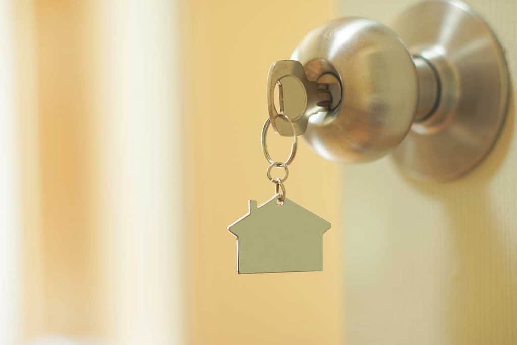 Home key with metal house keychain in keyhole