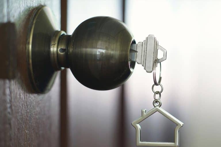 Home key with metal house keychain in keyhole, Do Door Knobs Come With Keys?