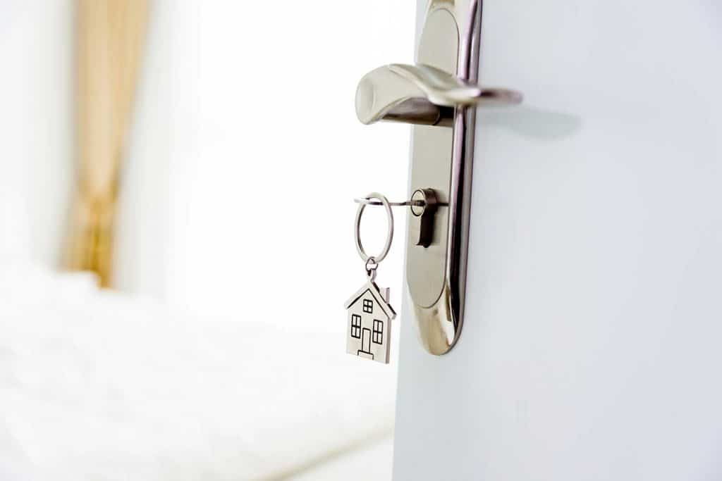 Key and house symbol keychain in a white door to a bedroom