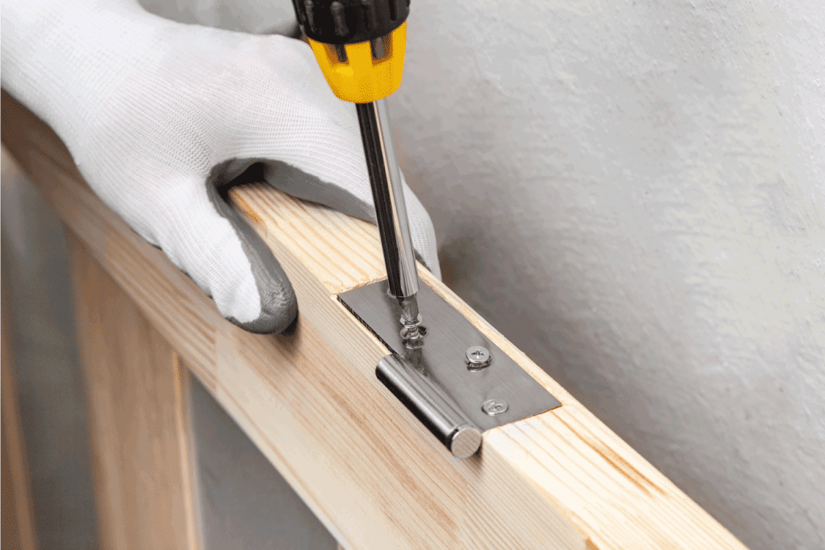 Screwing a door hinge to a wooden door frame