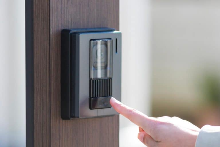 Woman pressing the interphone of the door, Is The Ring Video Doorbell Waterproof?