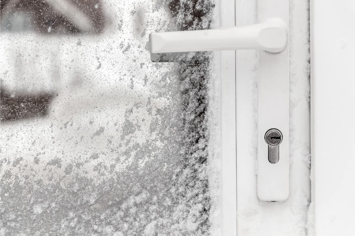 glass front door covered with snow and ice after a blizzard. How To Stop House Doors From Freezing Shut
