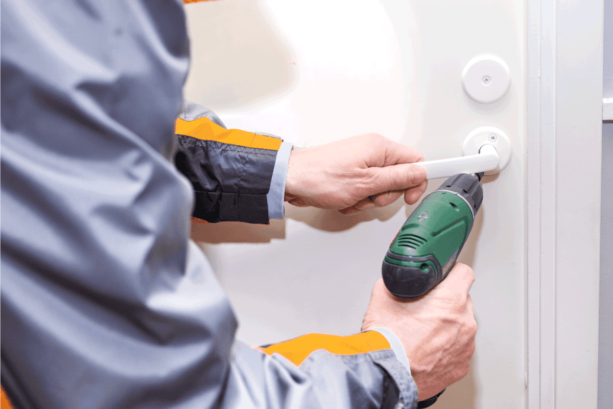 male with a cordless drill. Master repair the door lock and door handle.