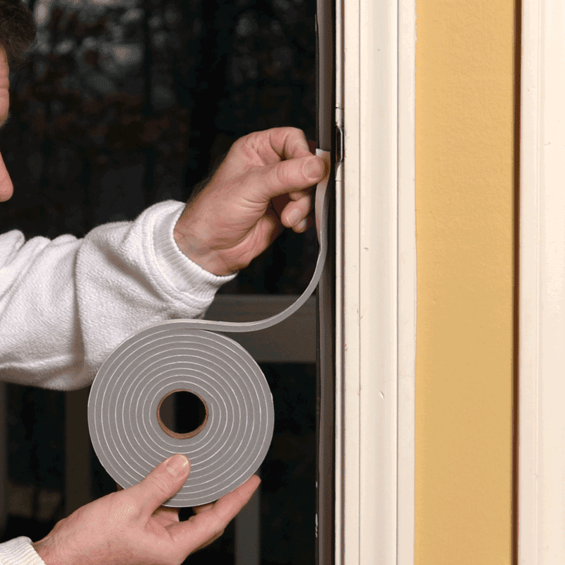 man replacing worn out weatherstripping with new one from a roll