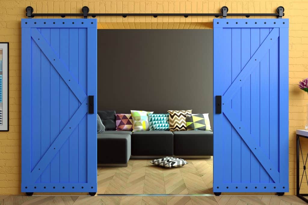 A blue painted barn door leading to an entertainment area