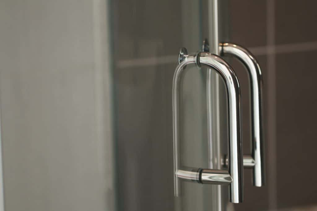 Stainless steel handle Of glass doors in the shower room. The image is partially clear.

