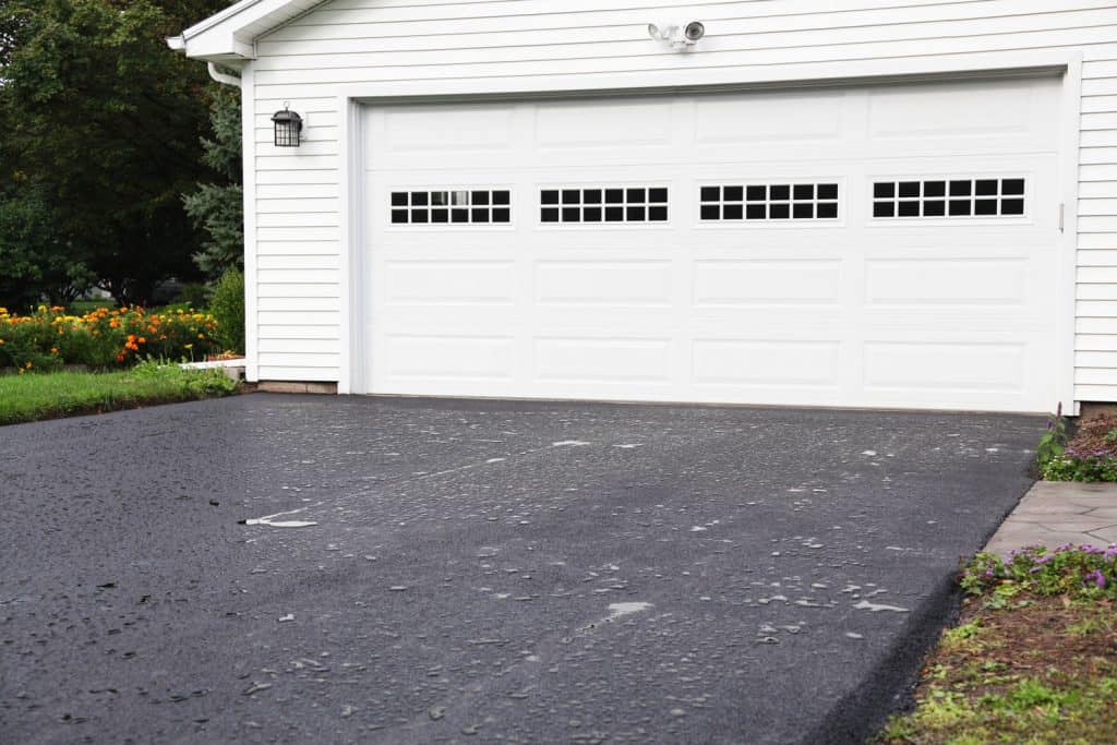 a brand new residential home blacktop asphalt driveway was completed
