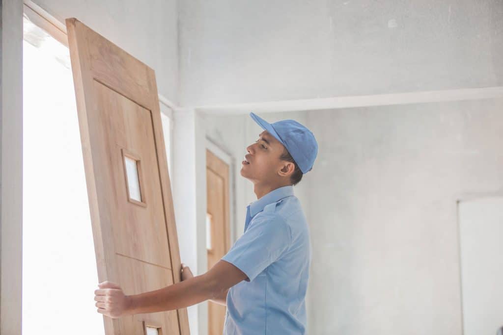 portrait of young asian worker installing doors
