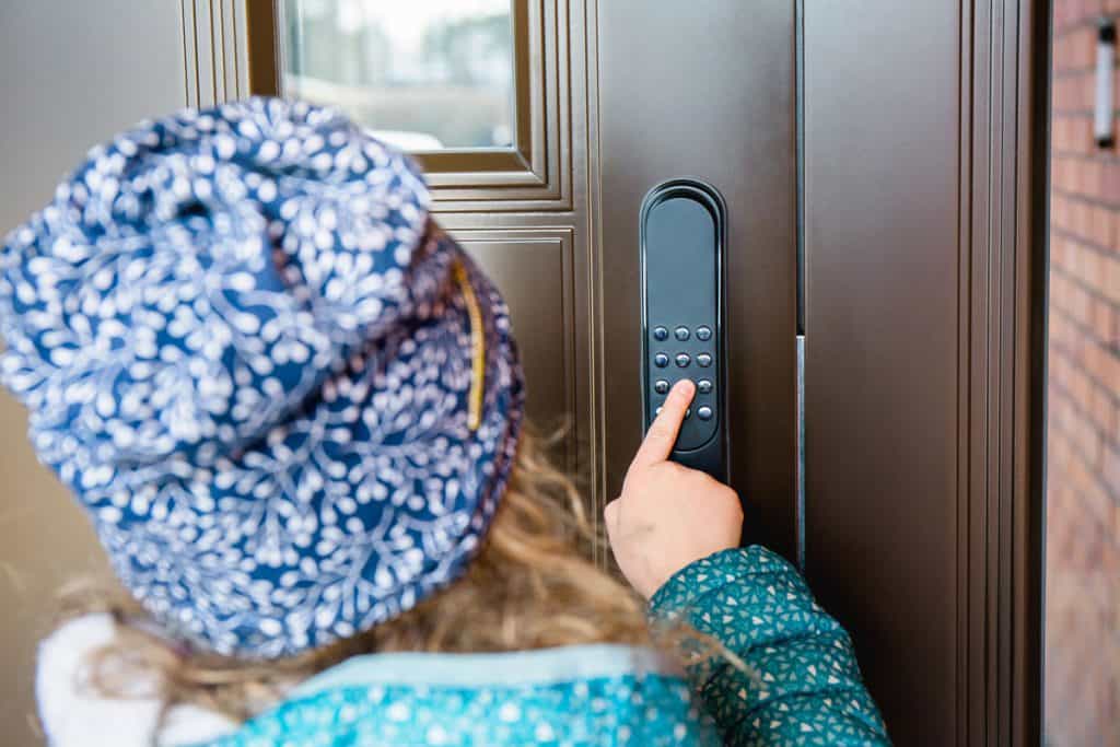 Little kid entering the passcode to the keyless door lock