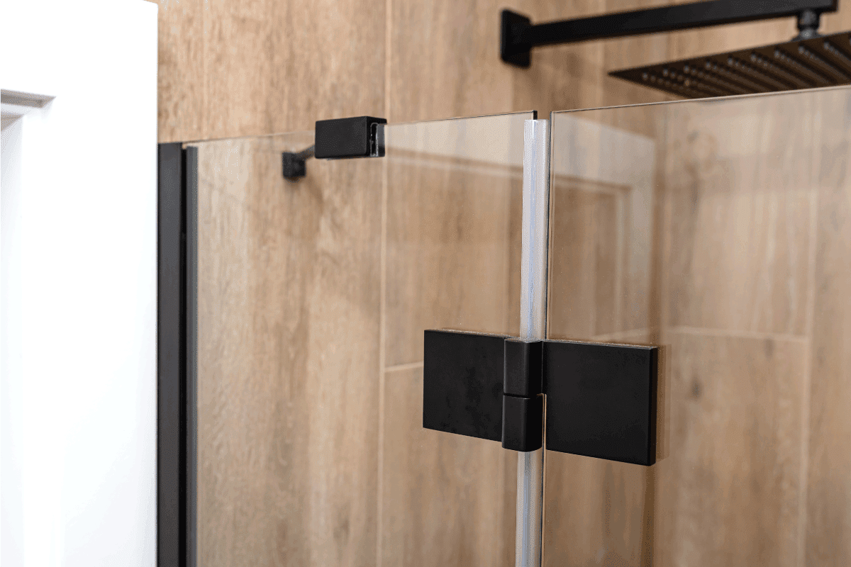 Black matt hinge connecting the wings of the shower enclosure flush with the glass