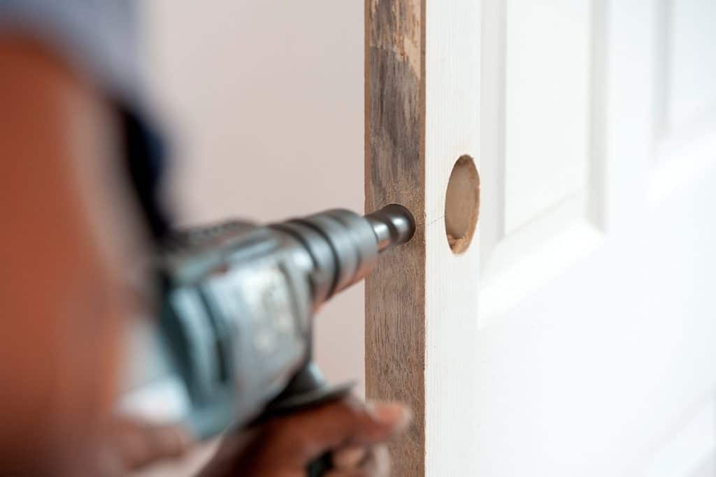 Worker drilling a hole on the side of the pocket for its lock