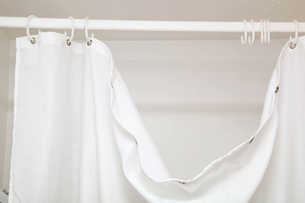 hanging dangling broken white shower curtain with hooks